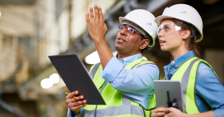 Engineers in PPE looking at a project on site